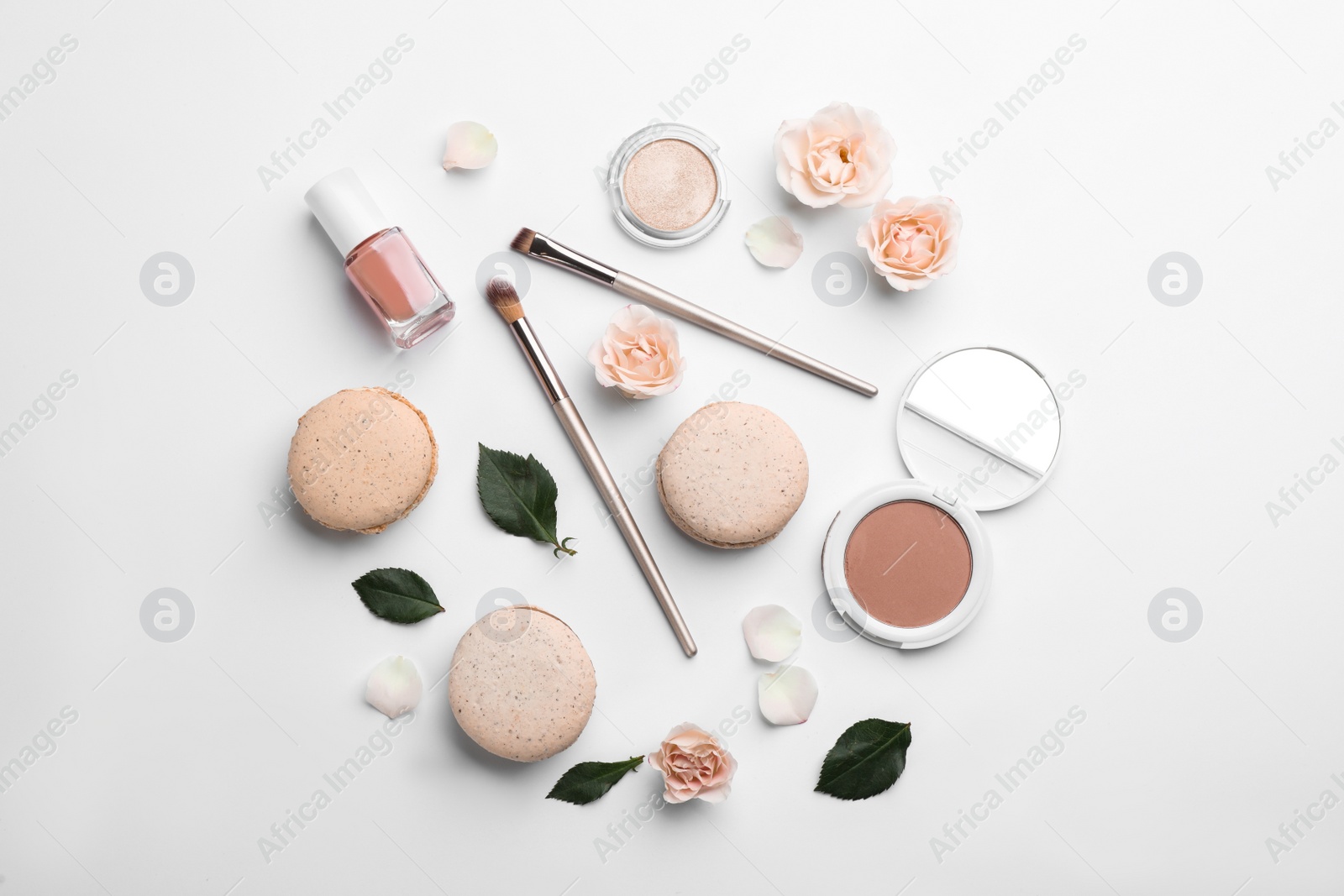 Photo of Flat lay composition with makeup products, roses and macarons on white background