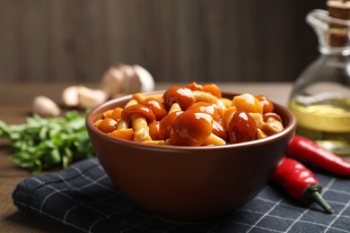 Photo of Tasty marinated mushrooms in bowl on table, closeup