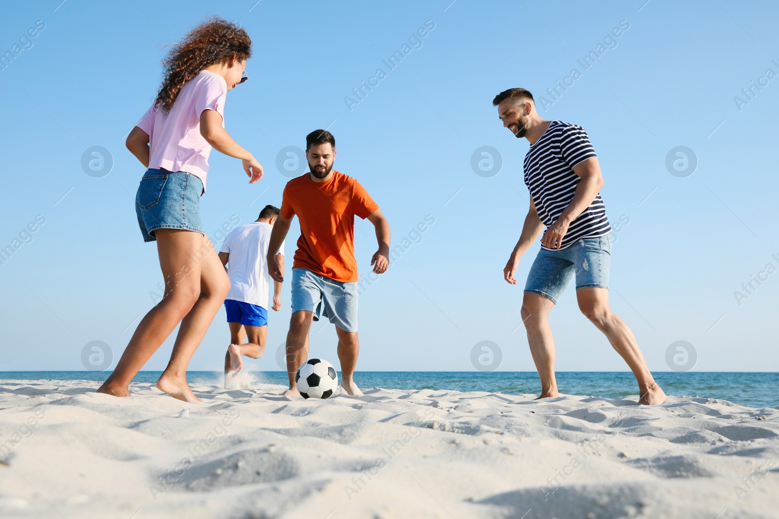 Photo of Group of friends playing football on beach