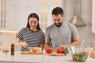 Photo of Lovely young couple cooking together in kitchen