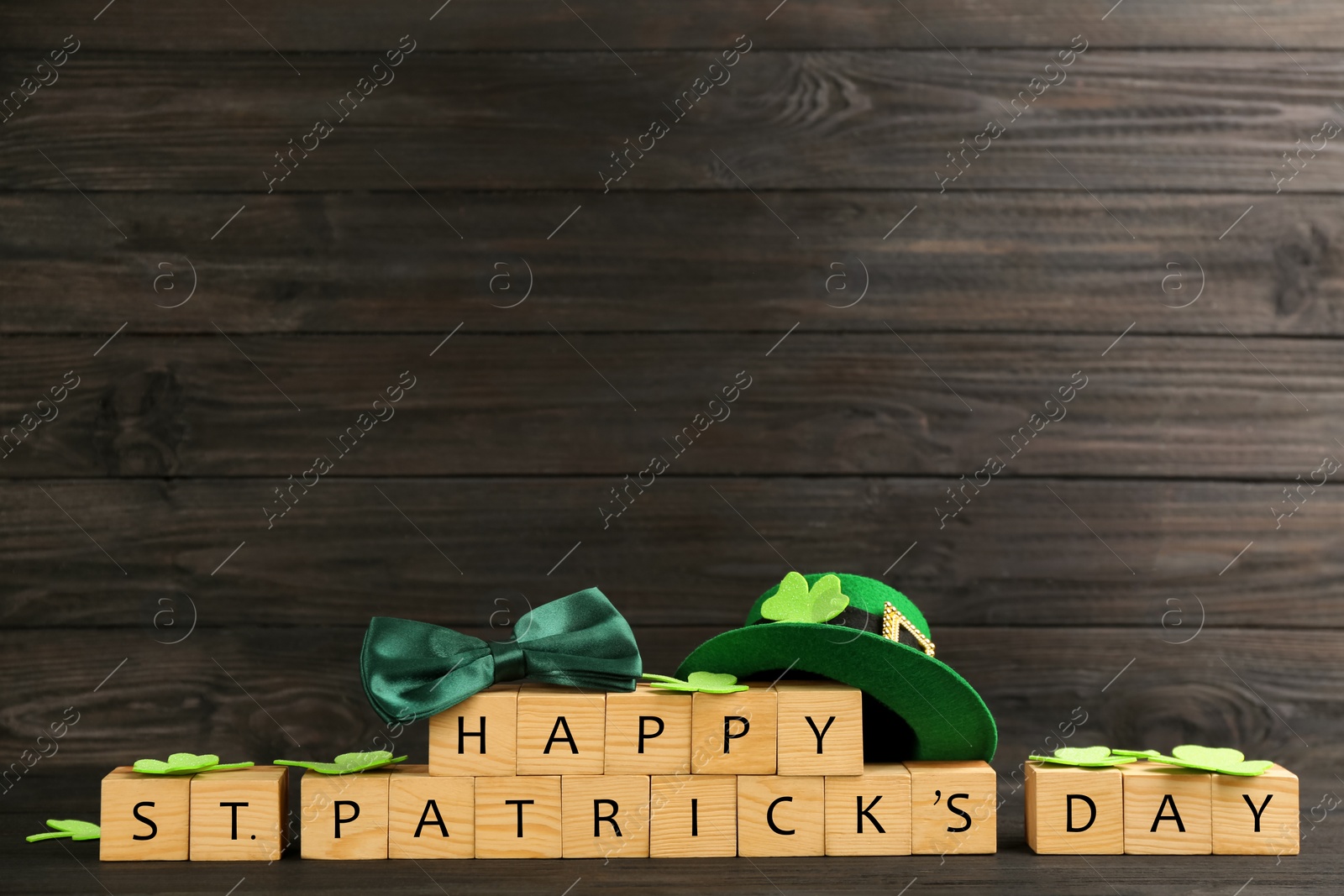 Photo of Words Happy St. Patrick's day and festive decor on black wooden background. Space for text