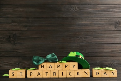 Words Happy St. Patrick's day and festive decor on black wooden background. Space for text