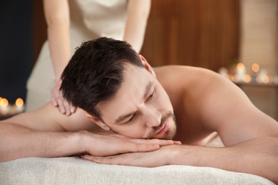 Photo of Handsome man receiving back massage in spa salon