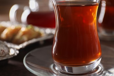 Photo of Traditional Turkish tea in glass on table, closeup