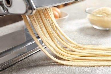 Pasta maker with dough on kitchen table