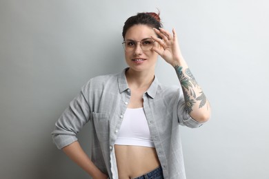 Portrait of beautiful tattooed woman on gray background
