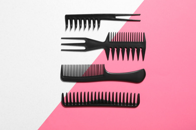 Photo of Set of black combs on color background, flat lay