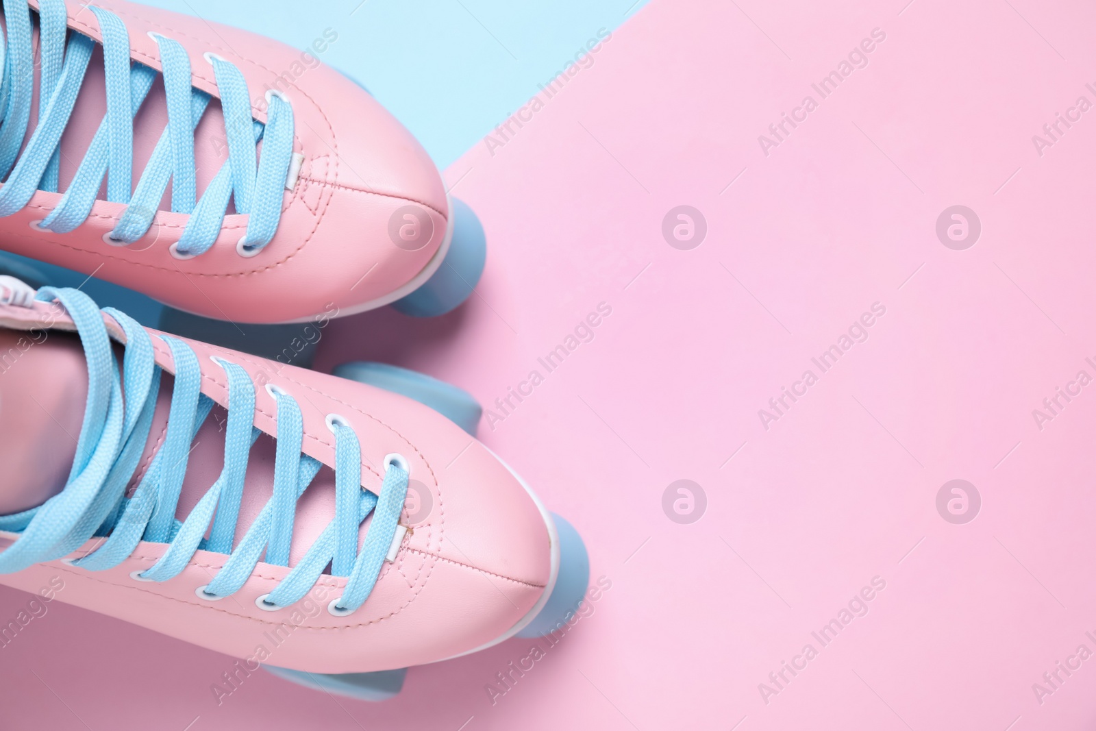 Photo of Pair of stylish quad roller skates on color background, flat lay. Space for text