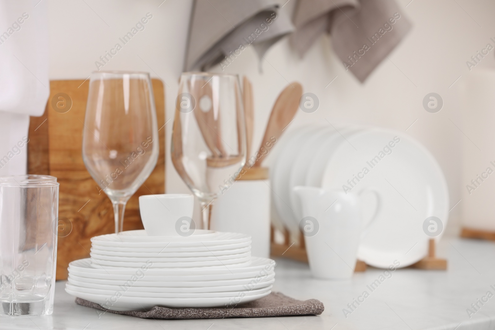 Photo of Clean dishes on light table in kitchen