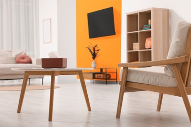 Stylish furniture near orange wall in room. Interior design