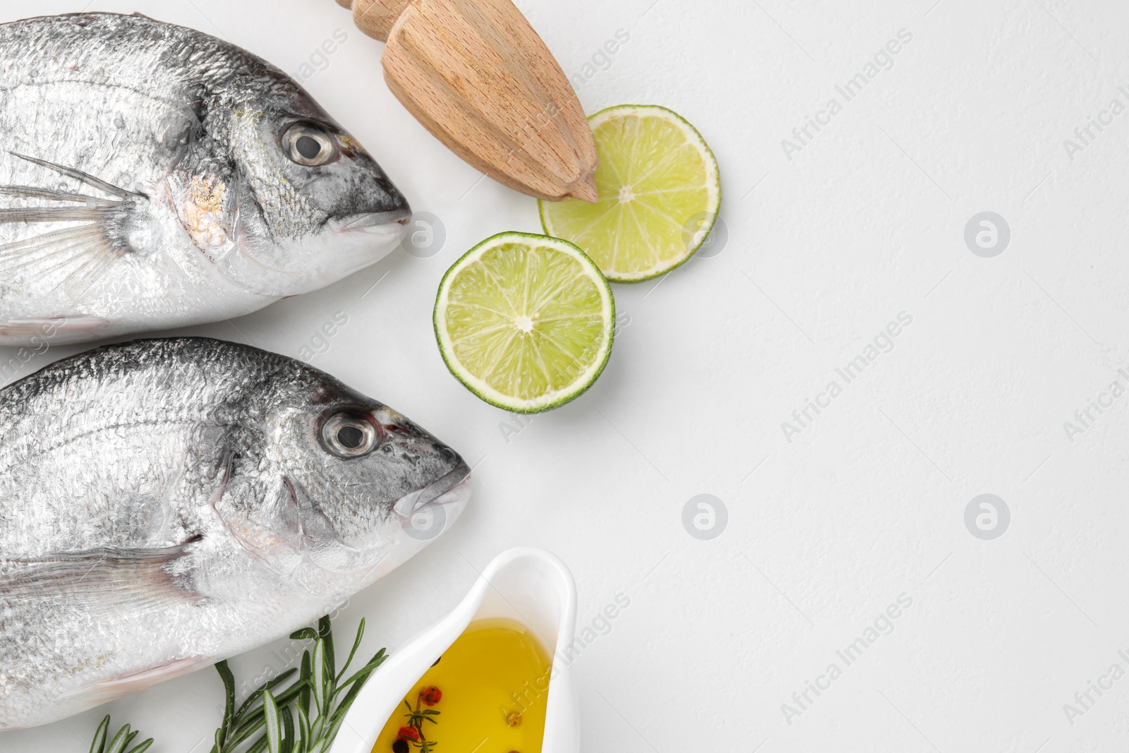 Photo of Fresh dorado fish and ingredients on white table, flat lay. Space for text