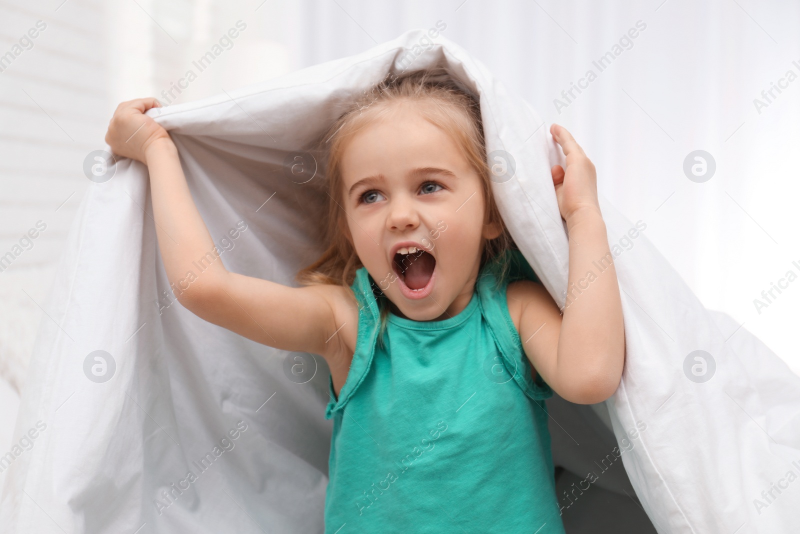 Photo of Cute little child playing on bed at home