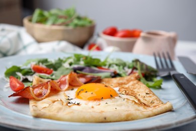 Photo of Delicious crepe with egg on table, closeup. Breton galette