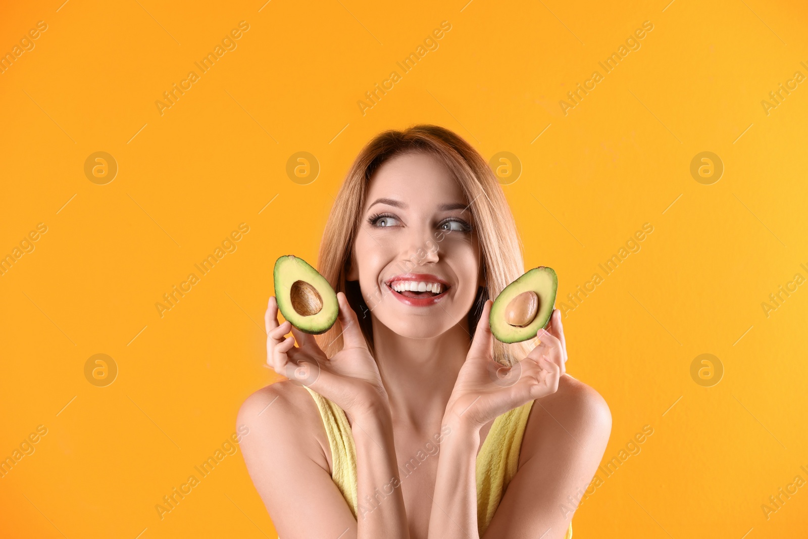 Photo of Portrait of young beautiful woman with ripe delicious avocado on color background