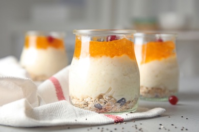 Creamy rice pudding with red currant and oatmeal in jar on table