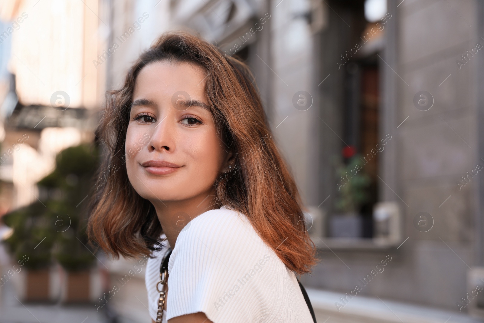 Photo of Portrait of happy young woman on city street