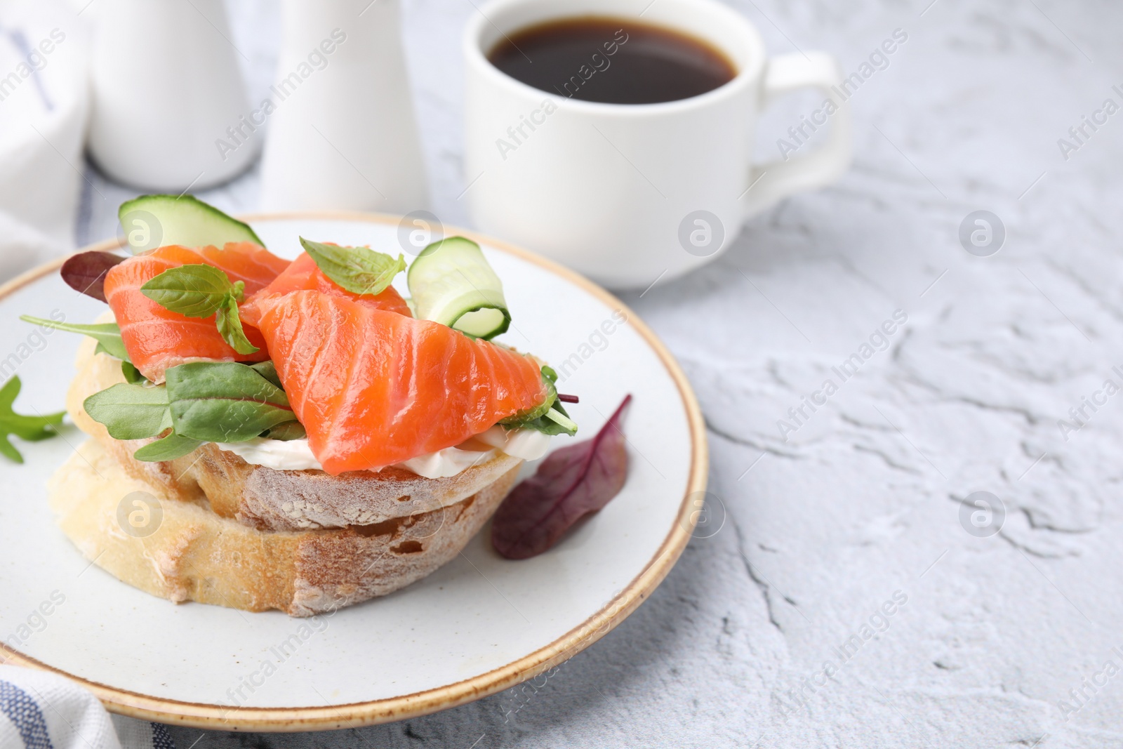 Photo of Tasty bruschetta with salmon, cucumbers and herbs on white textured table, closeup. Space for text