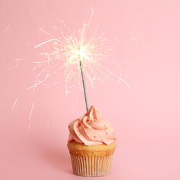Image of Birthday cupcake with sparkler on pink background