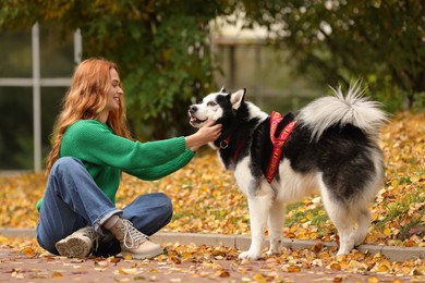 Photo of Happy woman with cute Siberian Husky in autumn park