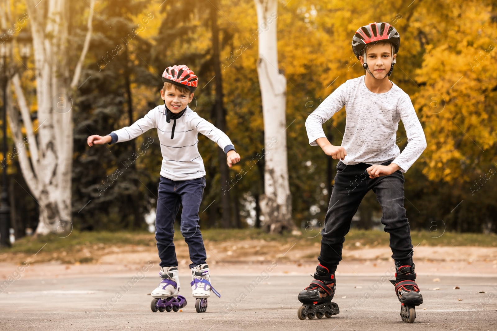 Photo of Happy children roller skating in autumn park