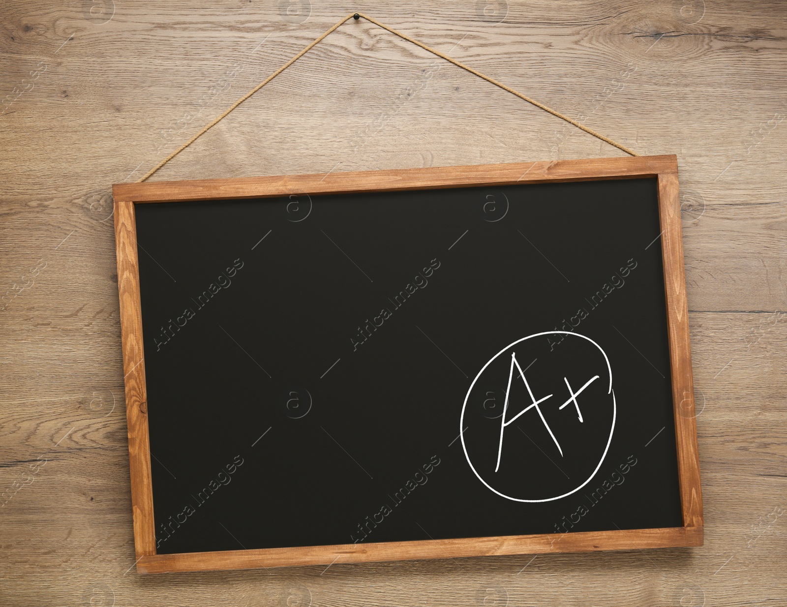Image of School grade. Small blackboard with chalked letter A and plus symbol on wooden wall