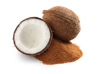 Ripe coconuts and pile of brown sugar on white background