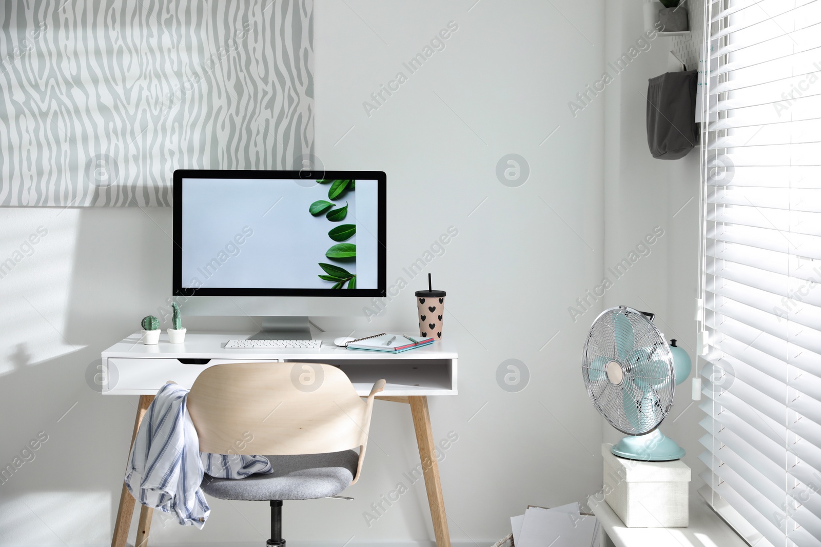 Photo of Comfortable office chair near desk with modern computer indoors