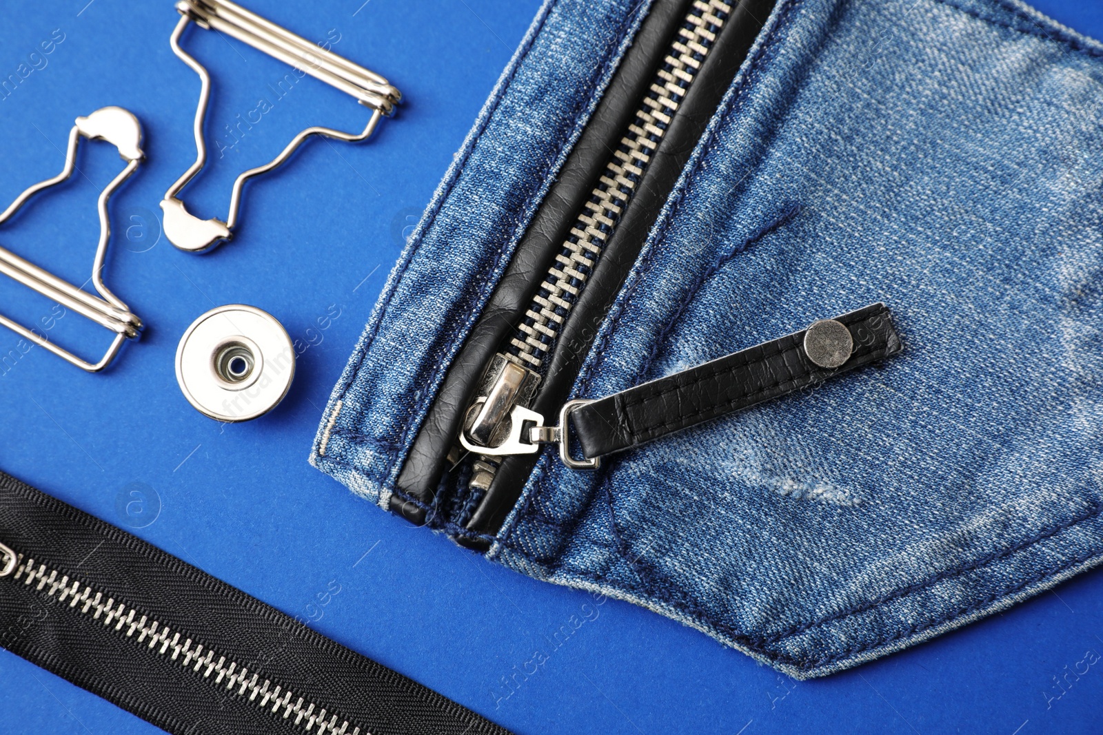 Photo of Flat lay composition with garment accessories and cutting details for jeans on blue background