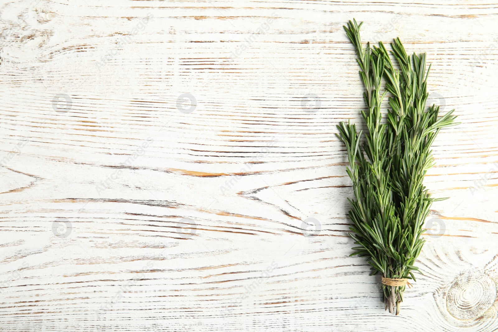 Photo of Bunch of fresh rosemary on wooden background, top view. Space for text