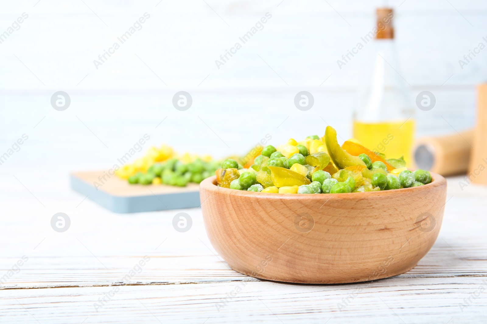 Photo of Bowl with frozen vegetable mix on wooden table