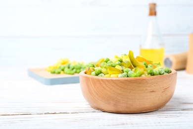 Photo of Bowl with frozen vegetable mix on wooden table