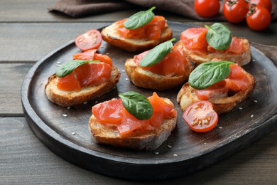 Photo of Delicious sandwiches with salmon and spinach on wooden table