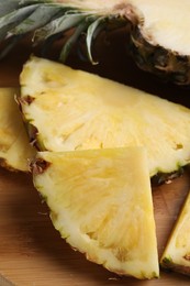 Photo of Slices of ripe juicy pineapple on wooden board, closeup
