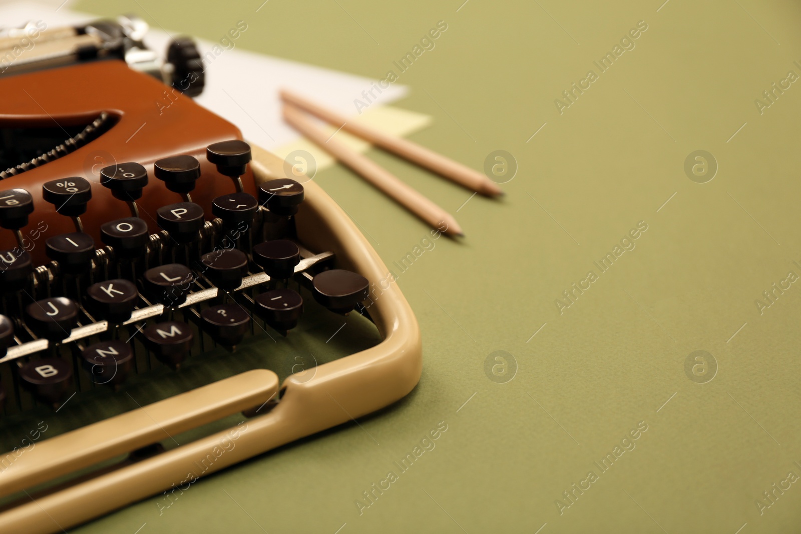 Photo of Vintage typewriter and stationery on green background, closeup. Space for text
