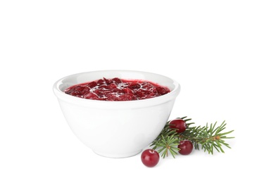 Bowl of cranberry sauce with fir tree branches on white background