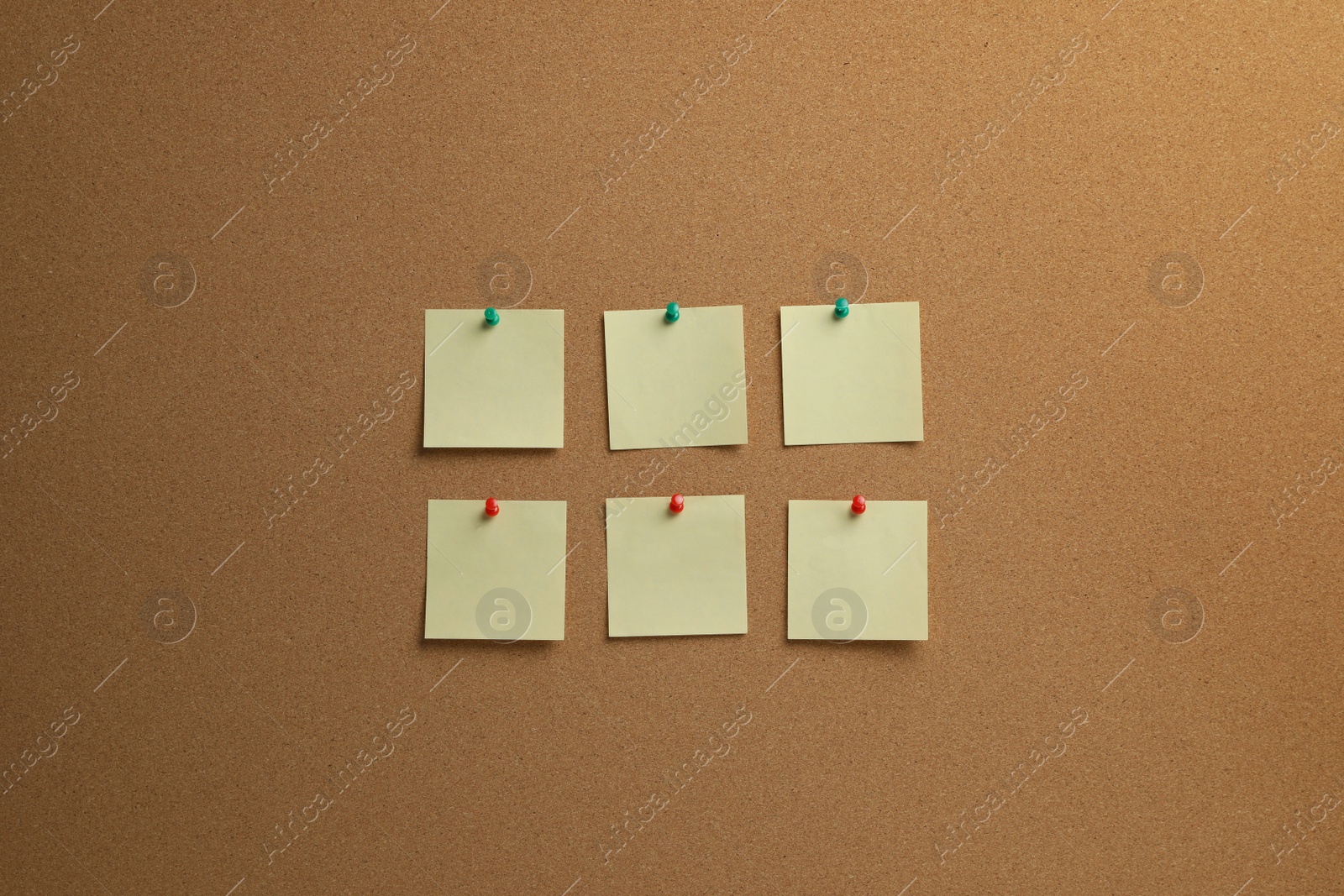 Photo of Beige paper notes pinned to cork board