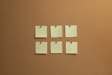 Photo of Beige paper notes pinned to cork board