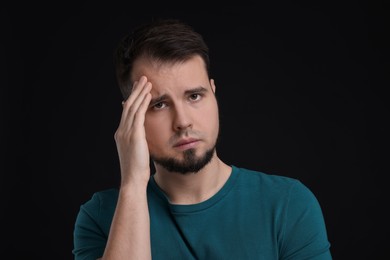 Portrait of sad man on black background