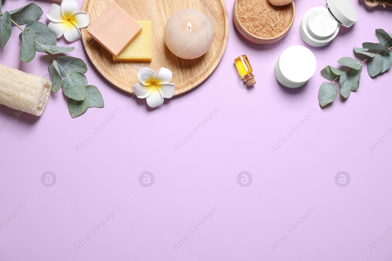 Photo of Flat lay composition with salt and cosmetic products on violet background. Space for text