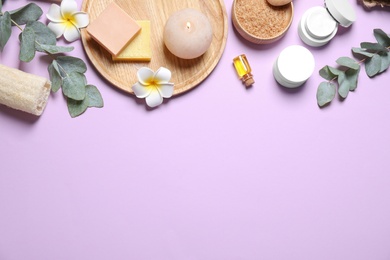 Photo of Flat lay composition with salt and cosmetic products on violet background. Space for text