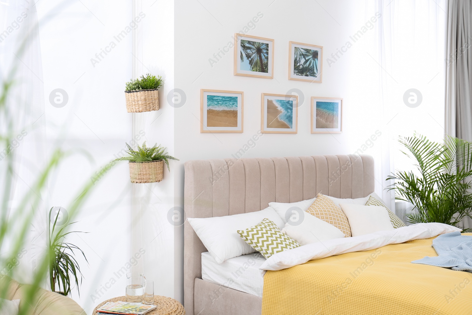 Photo of Stylish room interior with large comfortable bed and beautiful paintings