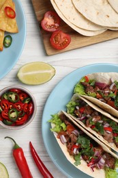 Photo of Flat lay composition with delicious tacos on wooden table