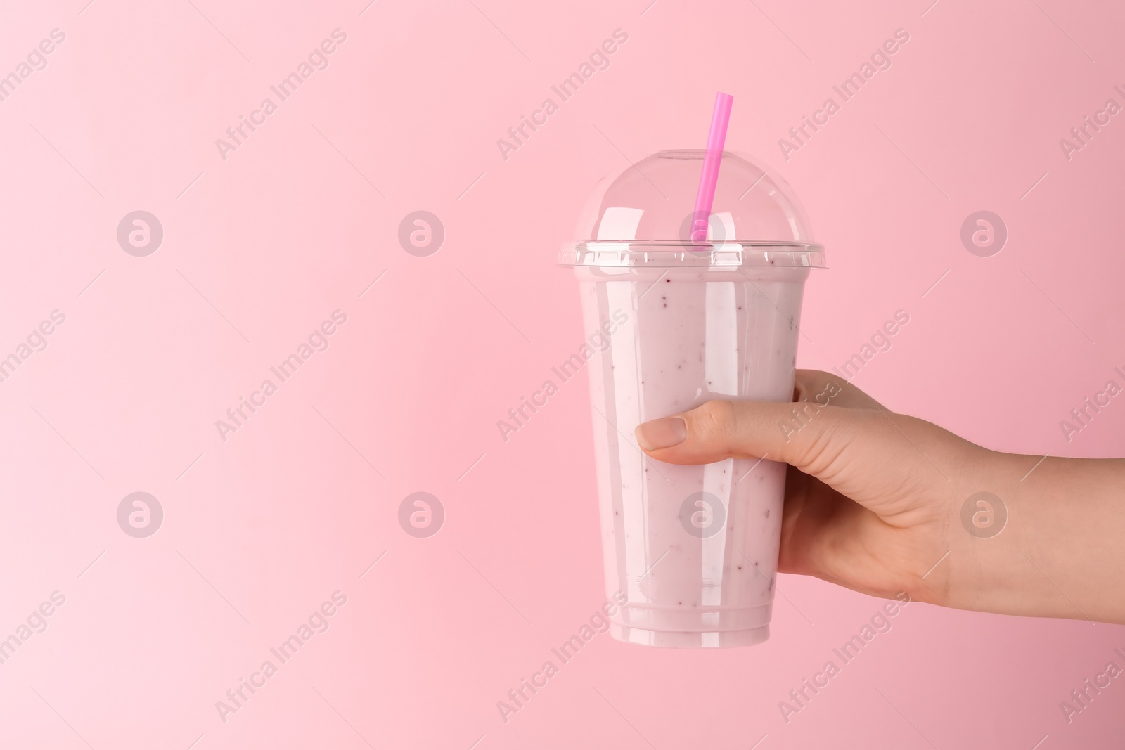 Photo of Woman with plastic cup of tasty smoothie on pink background, closeup. Space for text