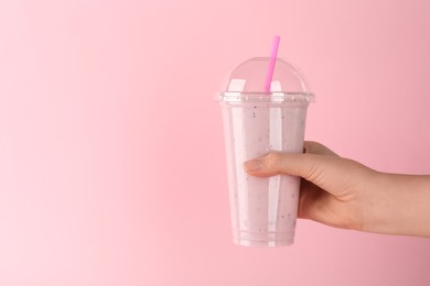 Photo of Woman with plastic cup of tasty smoothie on pink background, closeup. Space for text