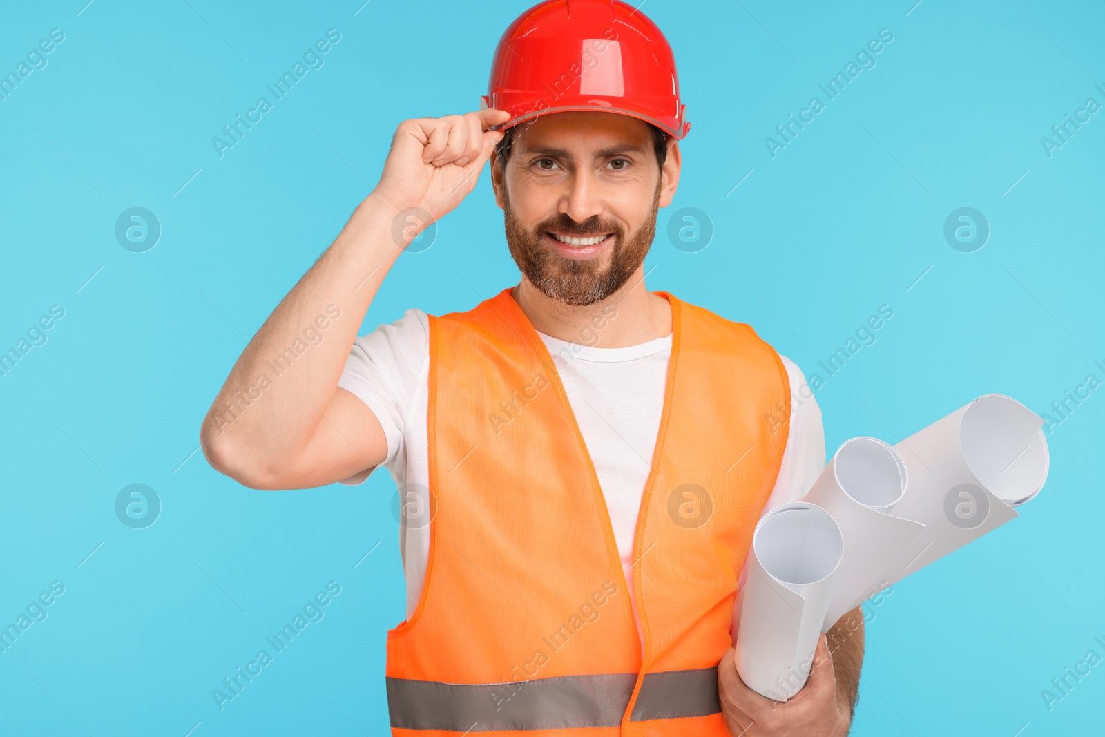 Photo of Architect in hard hat with drafts on light blue background