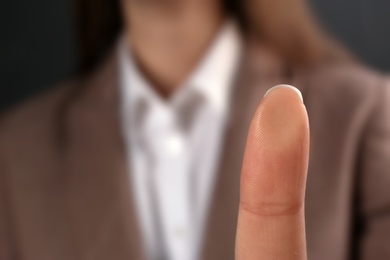 Businesswoman pressing control glass of biometric fingerprint scanner, closeup. Space for text