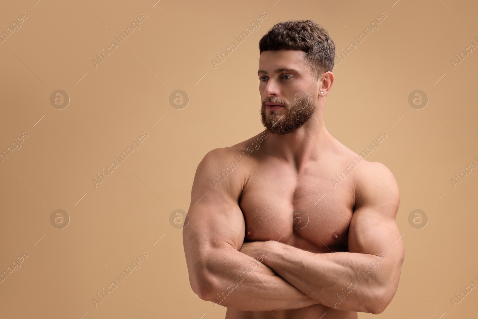 Photo of Handsome muscular man on beige background, space for text. Sexy body