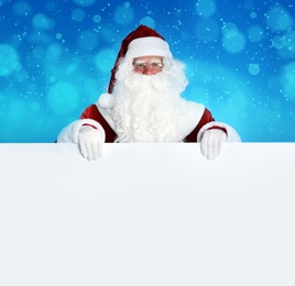 Image of Santa Claus with blank banner on blurred blue background. Space for design