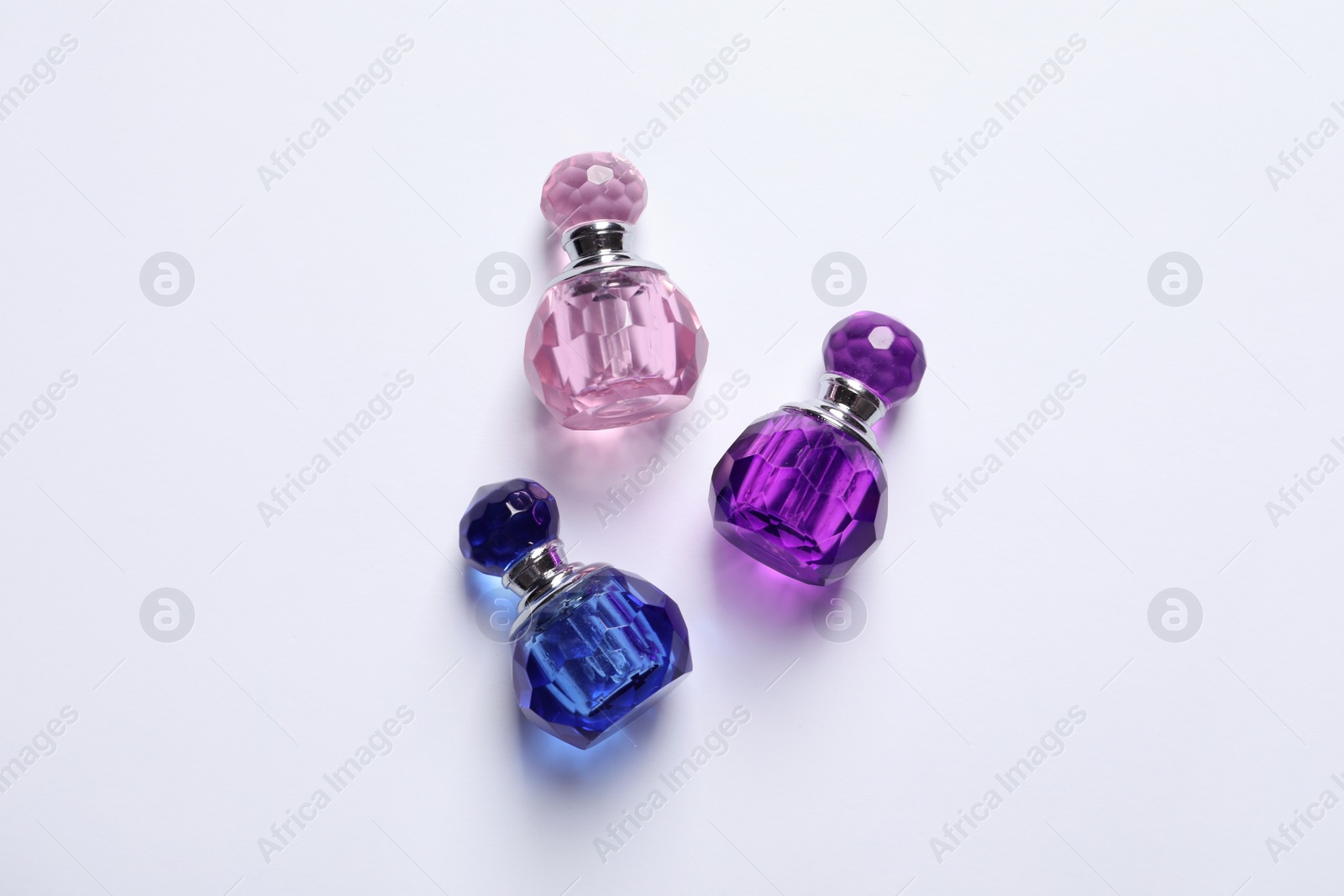 Photo of Composition with bottles of perfume on white background, top view