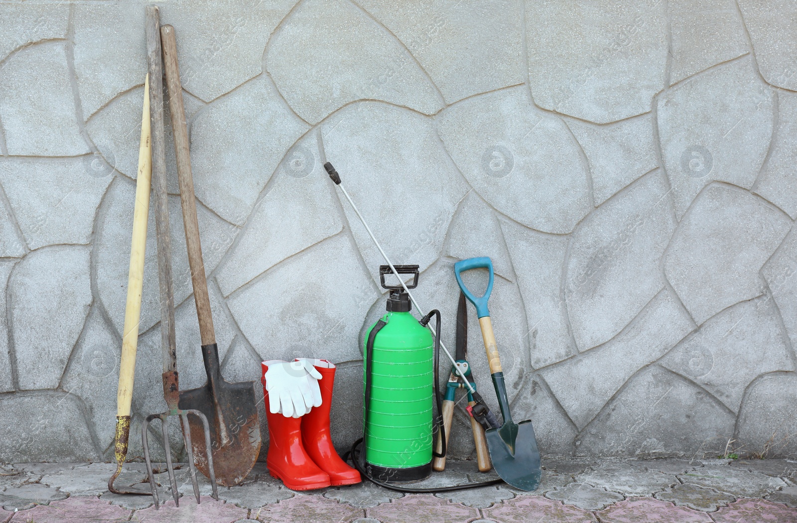 Photo of Set of gardening tools near wall outdoors. Space for text